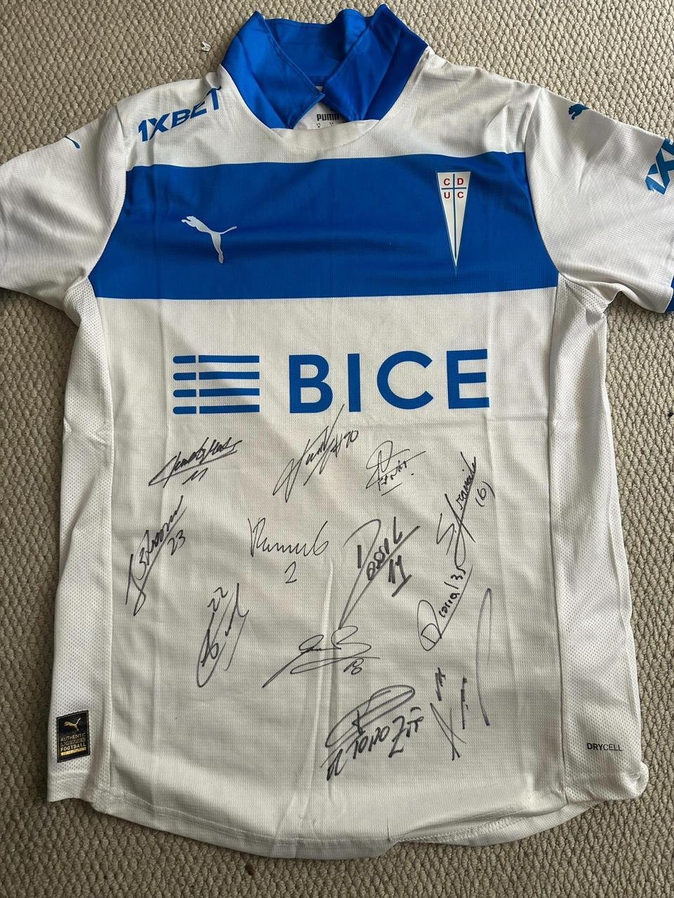 Camiseta Universidad Católica Local 2025 Puma. Autografiada por parte de la plantilla del primer equipo.